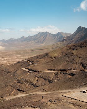 A breathtaking view of an arid mountain landscape with winding roads under a clear sky.