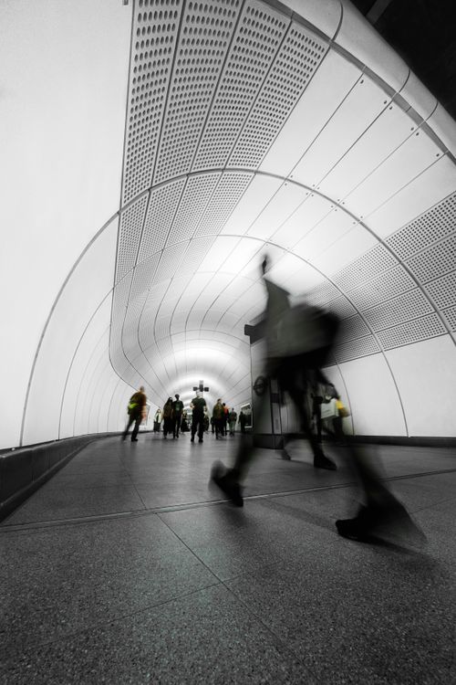 Free Blurred motion of people walking through a modern urban tunnel. Stock Photo