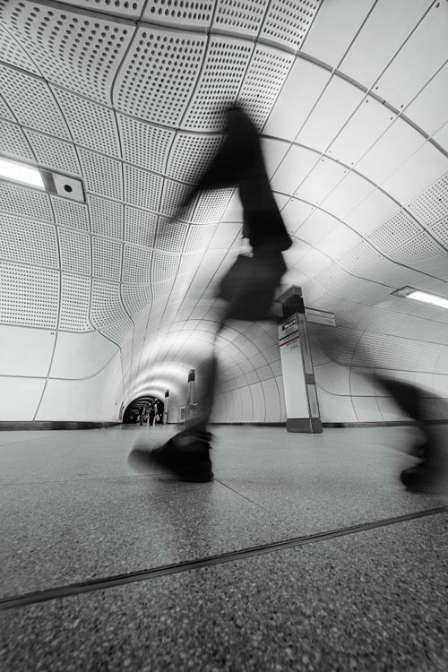 Free Motion capture in a modern subway corridor with a blurred walking figure. Stock Photo