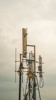 A telecommunication tower with antennas stands under a cloudy sky, showcasing modern technology.
