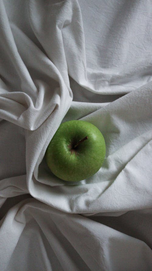 Foto stok gratis apel hijau, berbaring datar, kain putih