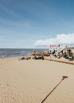 Relaxing scene at Palanga Beach with tourists and a scenic view of the Baltic Sea.