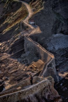 Dramatic aerial view of Gaztelugatxe pathway with rugged cliffs in Spain.