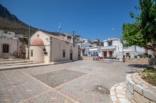 Free Beautiful empty town square in Crete with traditional architecture and Greek flags. Stock Photo