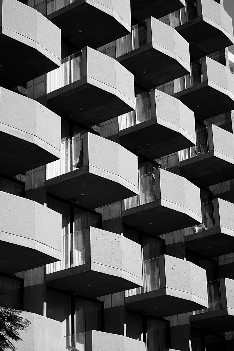 A Grayscale Of A Building With Balconies