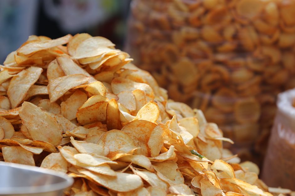 Piles of crispy, golden potato chips captured at a street food market in Bengaluru, India.