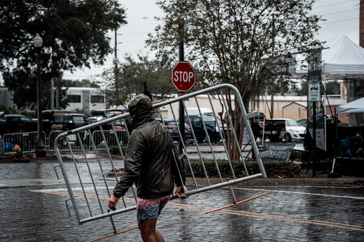 Photograph Of A Man Carrying A Fence