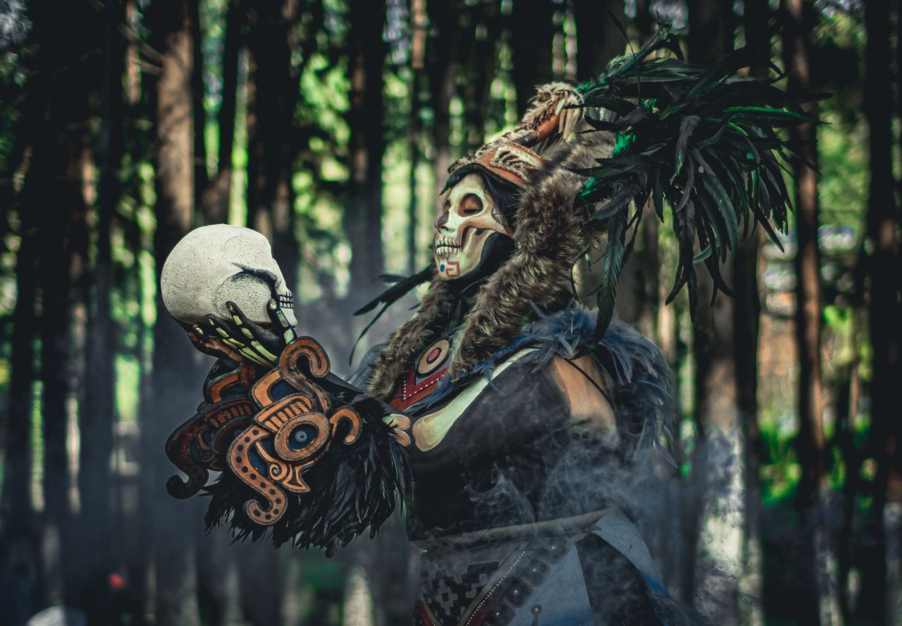 tribal themed costume and face paint with a skull in hand set against