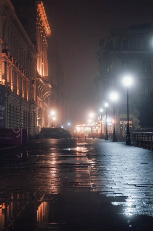 Wet Sidewalk in City at Night 