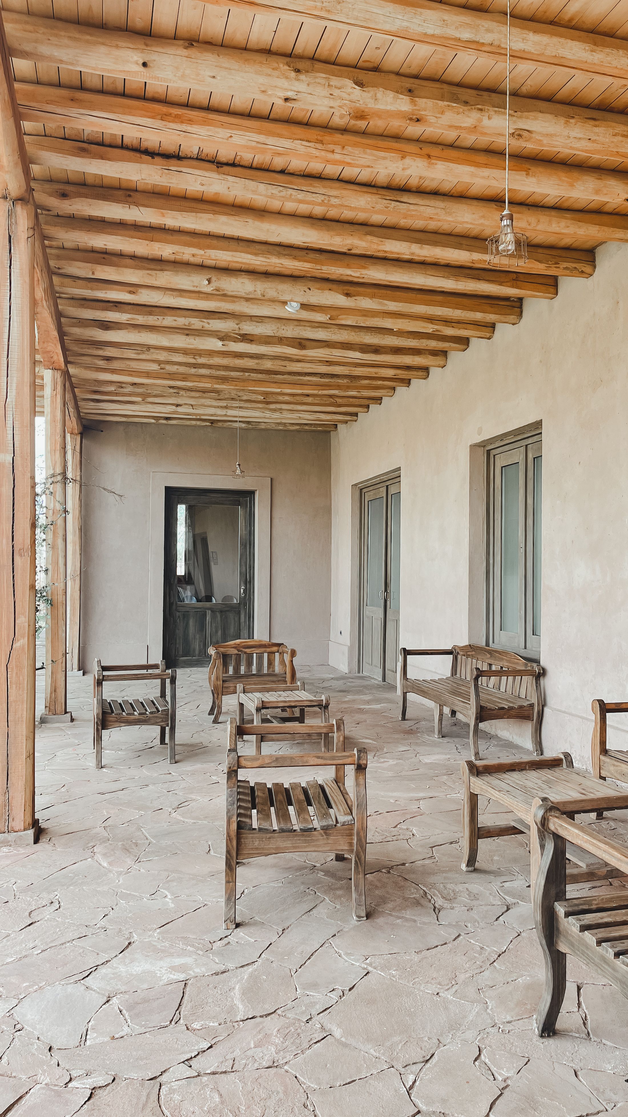 Shaded veranda with wooden chairs and a timber ceiling