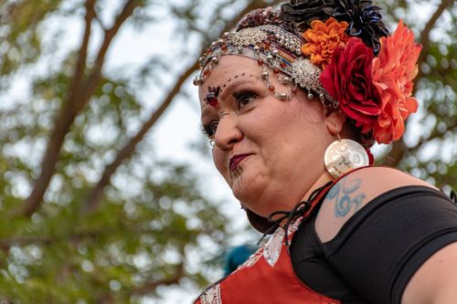 Free A woman in vibrant clothing with floral headdress poses outdoors, exuding cultural beauty. Stock Photo
