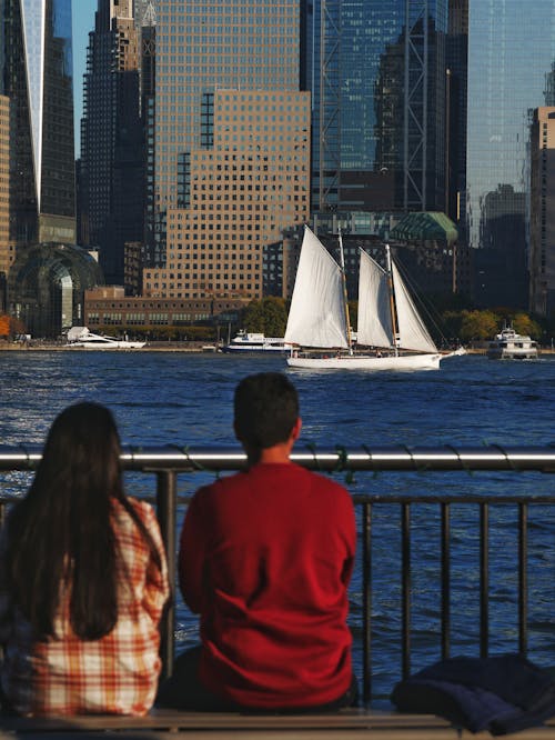 People Looking at a Ship in the Harbor on the Background of New York City Skyscrapers 