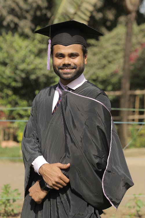 A Man in Black Graduation Gown Smiling at the Camera · Free Stock Photo