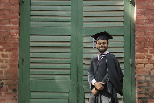 A Man with a Square Academic Cap Smiling