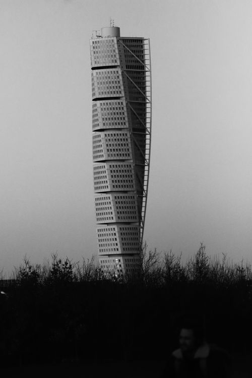 Free Artistic black and white shot of a unique twisting skyscraper against the sky. Stock Photo