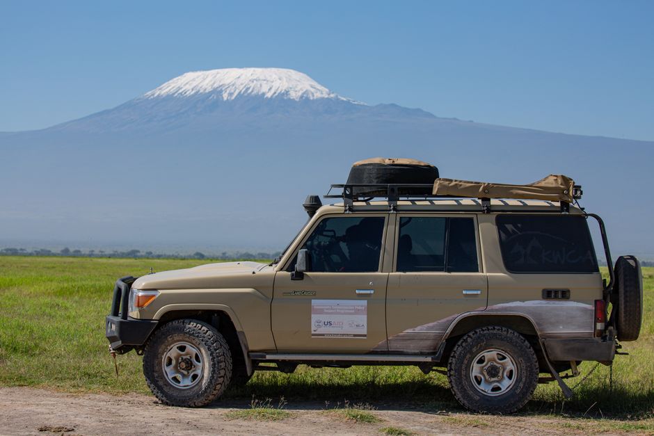 Incredible 7 Days Mount Kilimanjaro Climbing via Machame Route Review 2026 - Off-road SUV parked in front of Mount Kilimanjaro, showcasing adventure travel and scenic landscapes.