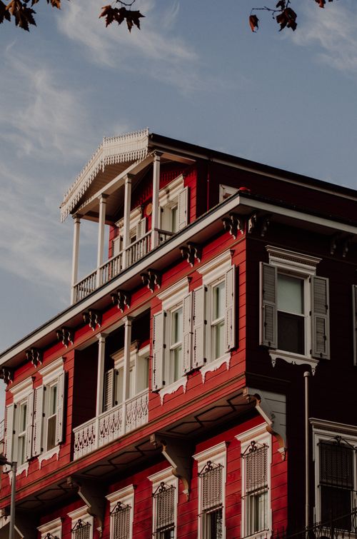 Free Stunning red Ottoman-style building facade with white shutters and balconies in İstanbul, Turkey. Stock Photo
