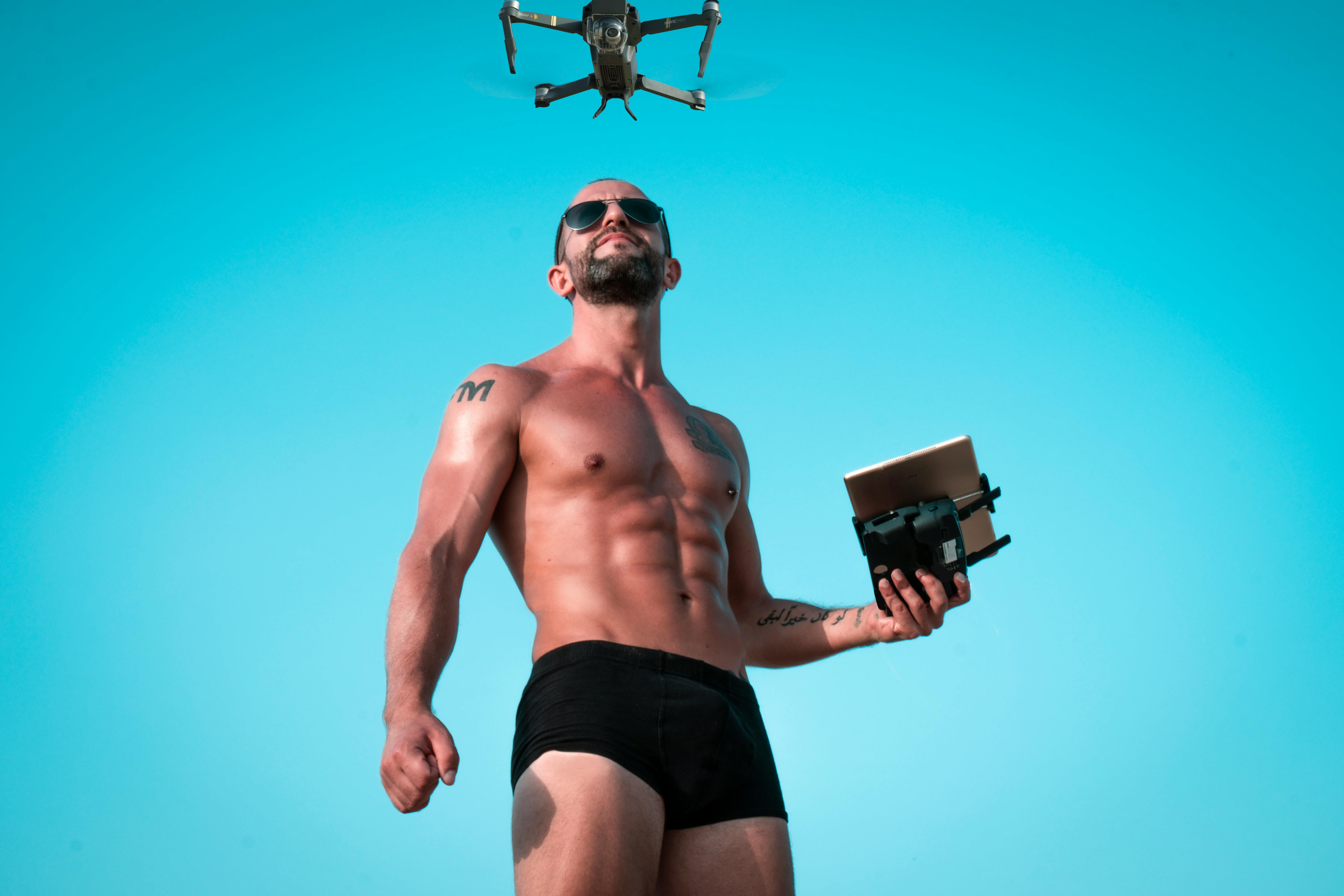 photo of man controlling black drone