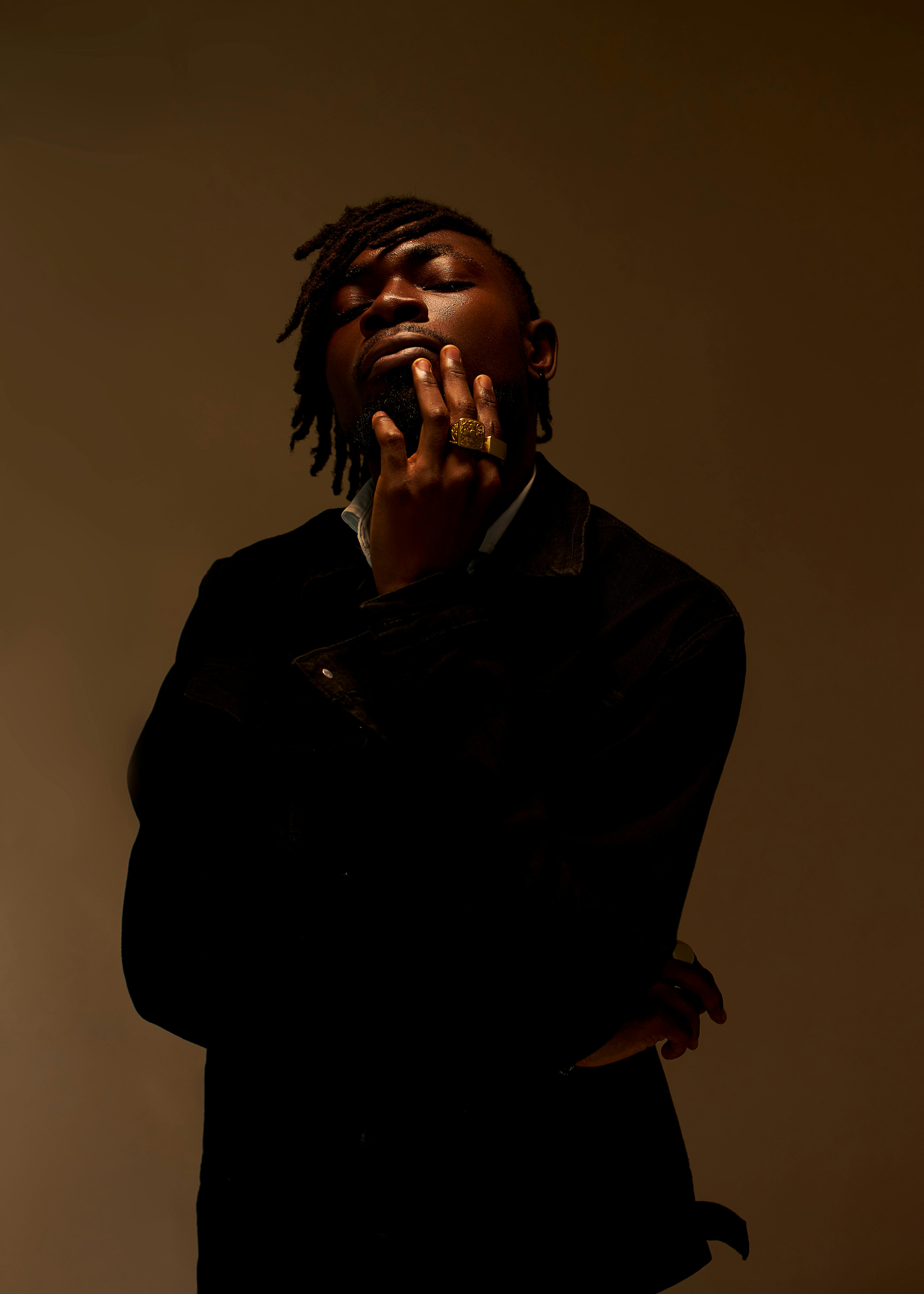 Dramatic portrait of an African American man posing thoughtfully. Perfect for fashion and lifestyle themes.