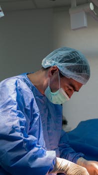 Surgeon wearing a surgical cap and mask concentrating on a procedure in an operating room.