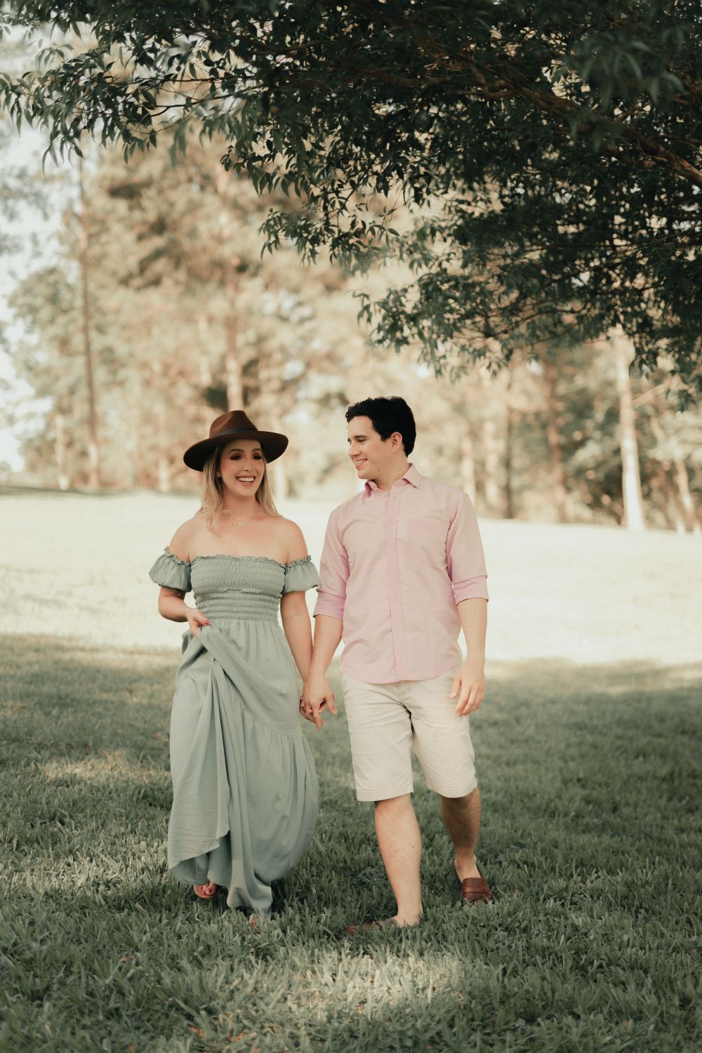 Happy Couple Walking on a Park Holding Their Hands · Free Stock Photo