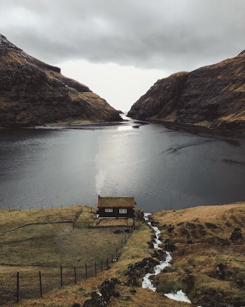 Scenic Photo of a Cottage House by the Fjord