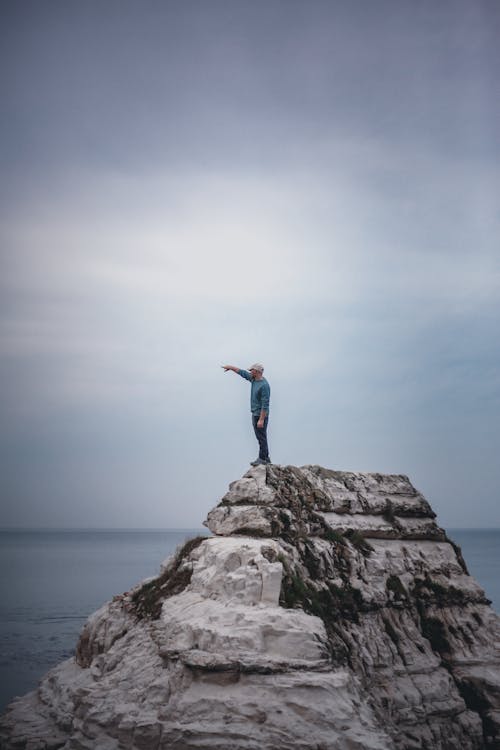 Man Standing on the Rock under the Sky