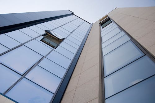 無料 ローアングル写真のガラス窓と灰色のコンクリートの建物 写真素材