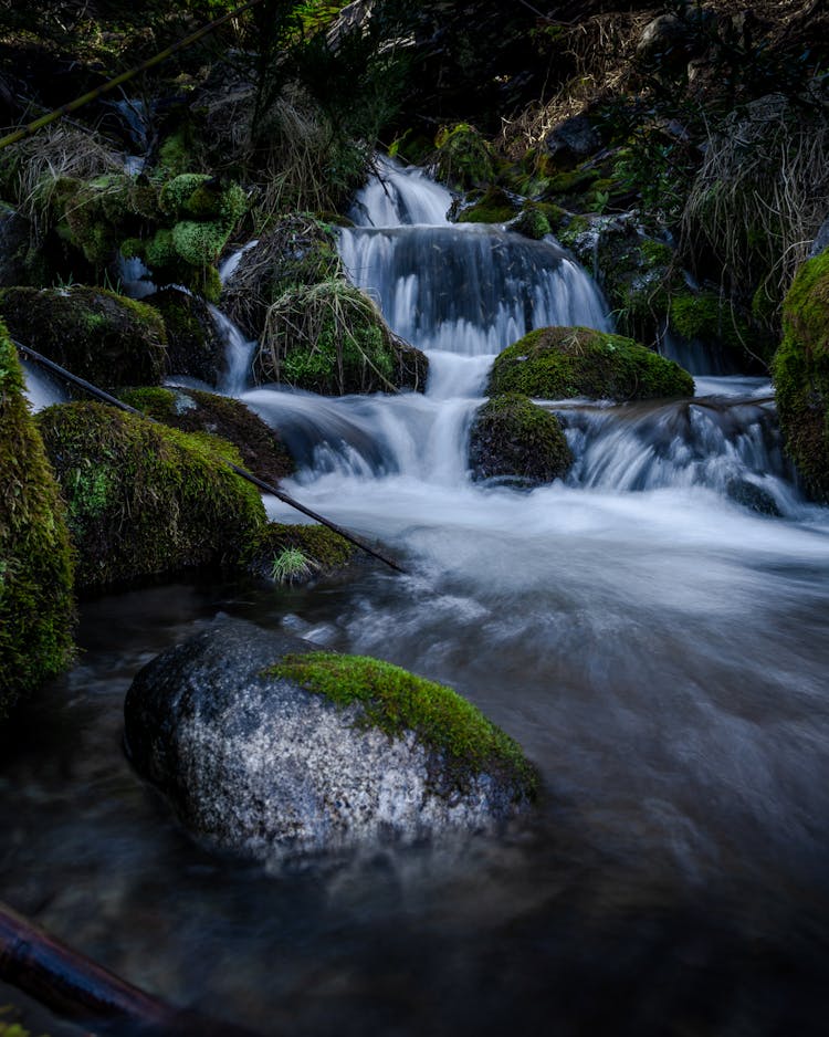 Long Exposure Of A River Splashing Down Between Mossy Boulders