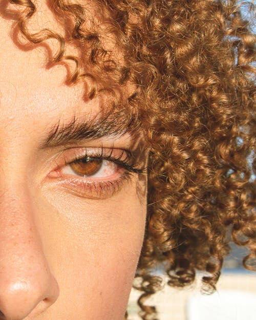 A Close-up Shot of a Woman in Blonde Curly Hair