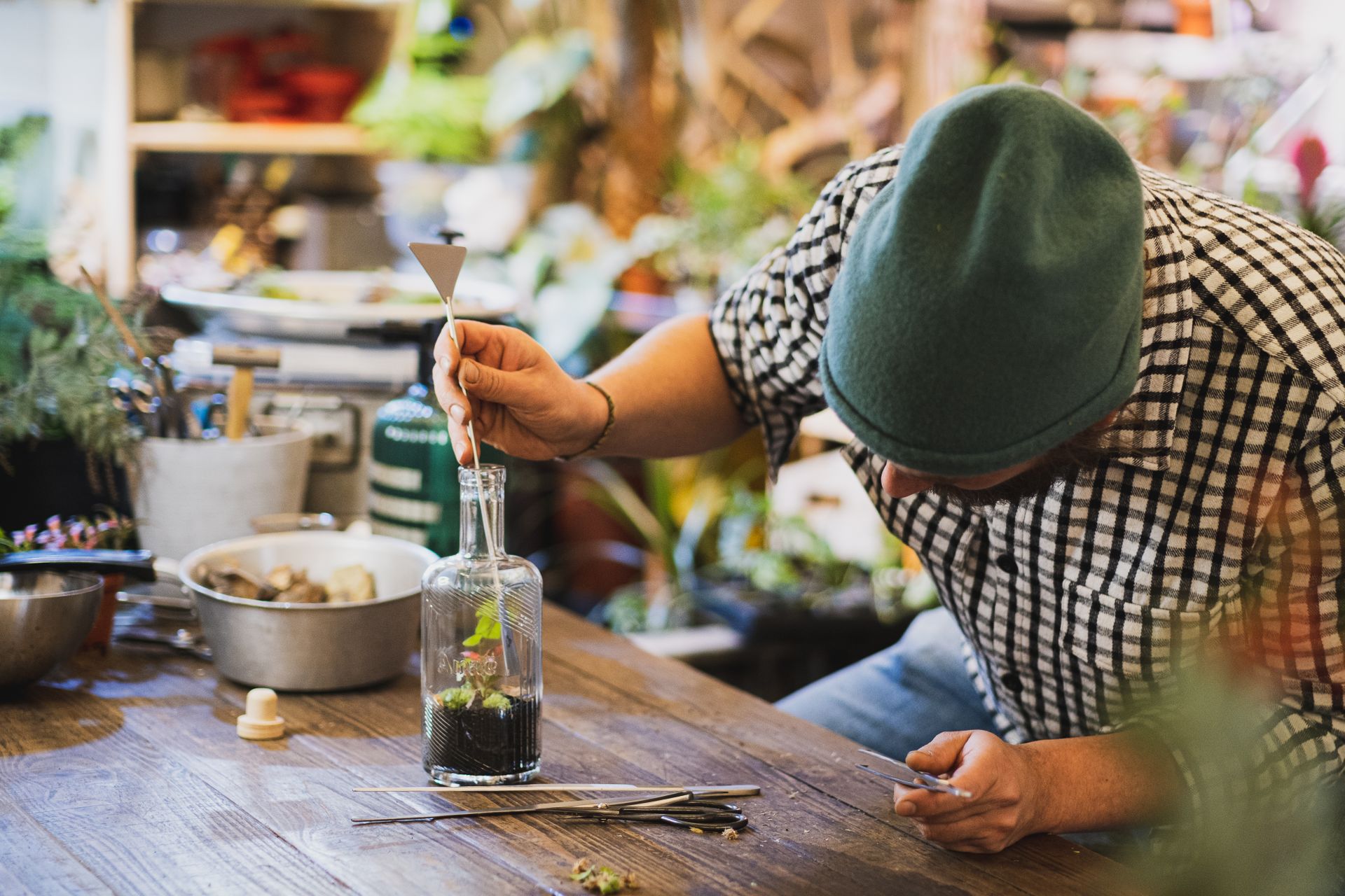 Florist Making Plant Design Inside a Glass Bottle