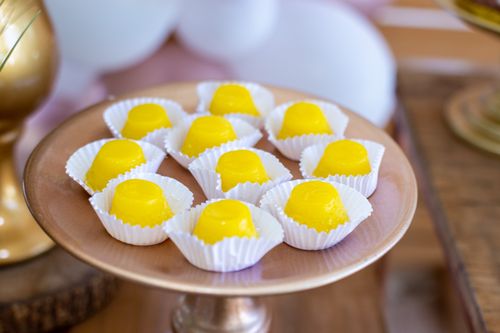 Free Vibrant yellow candies displayed on an elegant tray, perfect for a celebration or party setting. Stock Photo
