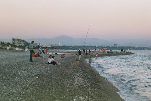 People Relaxing on a City Beach at Dusk