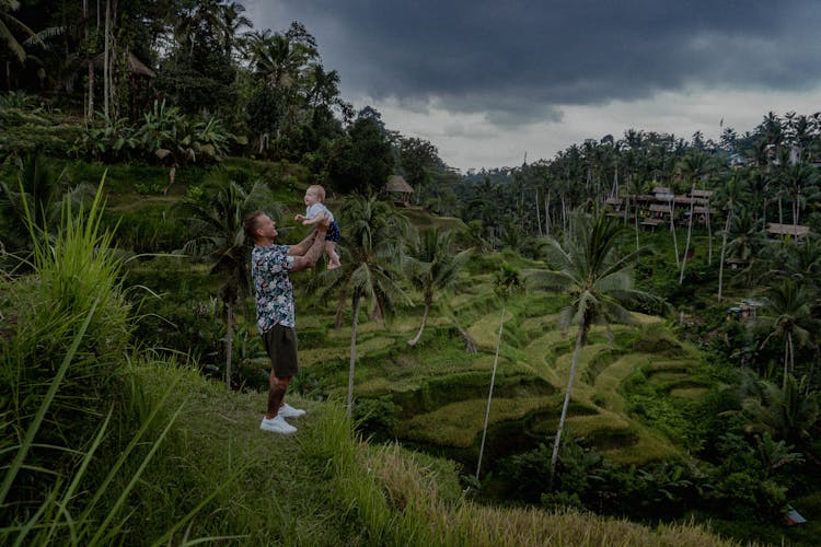 A Father Carrying A Baby