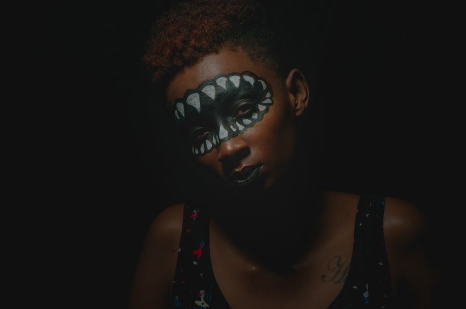 Stunning dark portrait of a woman with unique face paint in Mombasa, Kenya.