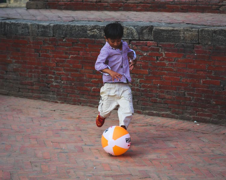 A Boy Kicking The Ball