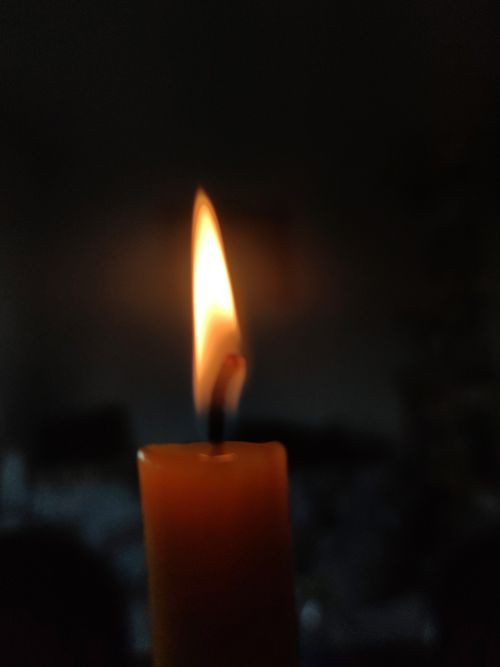 Free A single candle burns softly in the dark, casting gentle light. Stock Photo