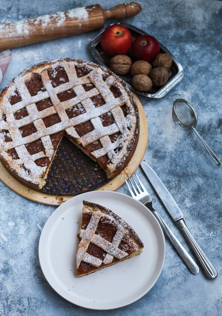 Delicious homemade apple pie with lattice crust and walnuts, perfect for a cozy dessert setting.