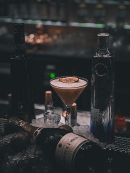Stylish cocktail with lime garnish in a dimly lit bar. Perfect for nightlife and beverage themes.