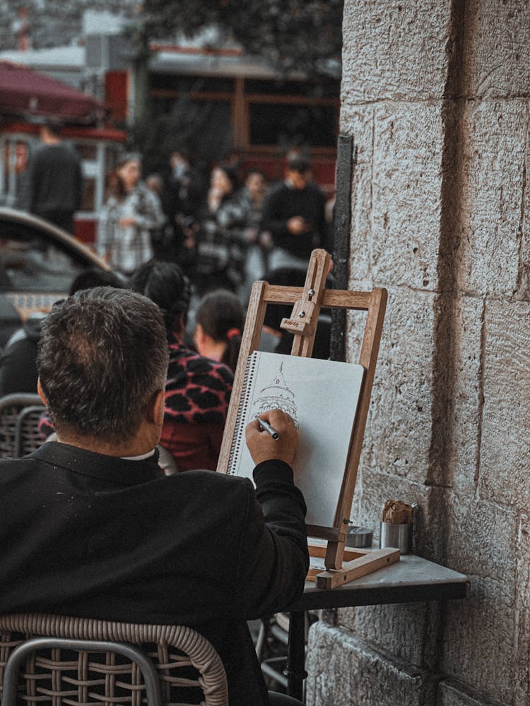 A Man Drawing On Paper 