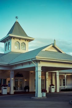 Elegant colonial-style facade with a central tower against a clear blue sky.