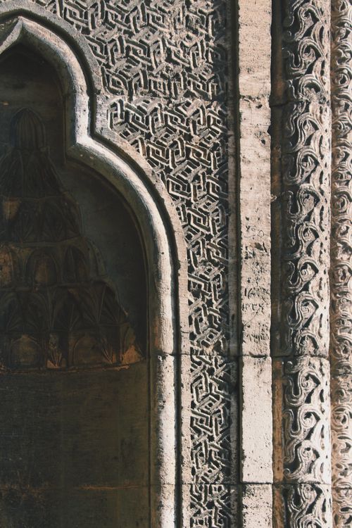 Free Close-up of an ornate stone archway featuring intricate geometric patterns, showcasing historic architectural design. Stock Photo