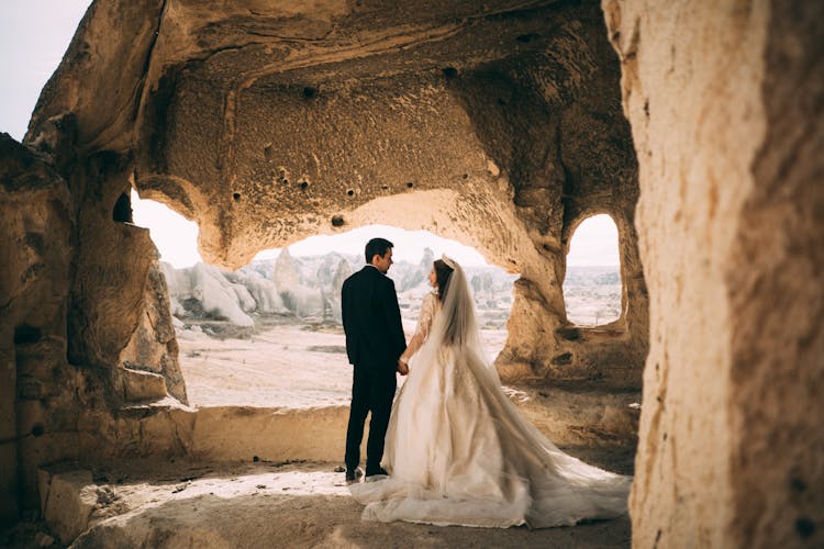 Newlyweds Standing Together Under Rocks