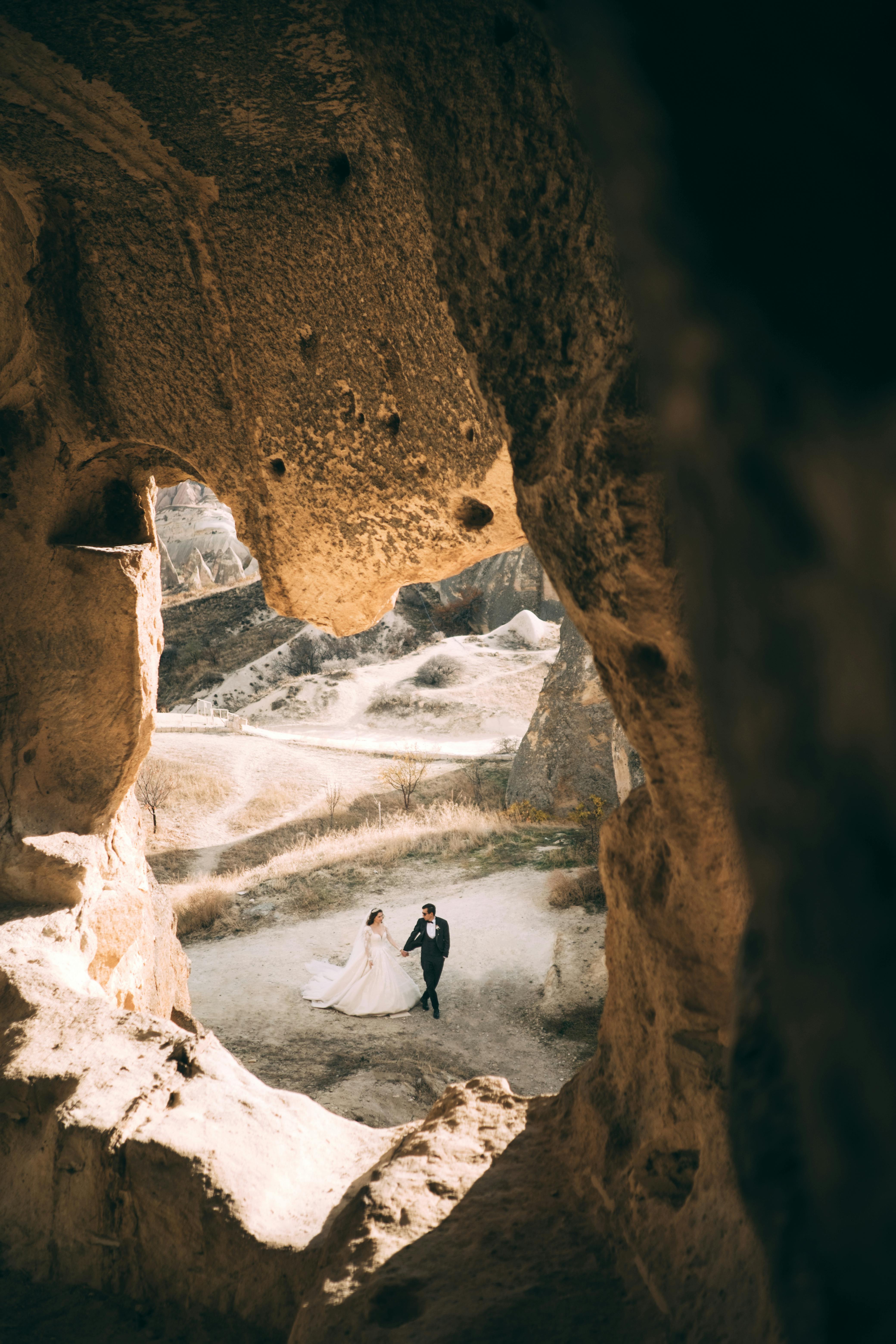 newlyweds walking together among rocks