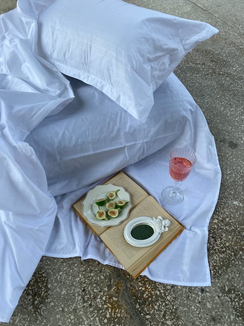 Free Open Book and Snacks on the Bed Outdoors  Stock Photo