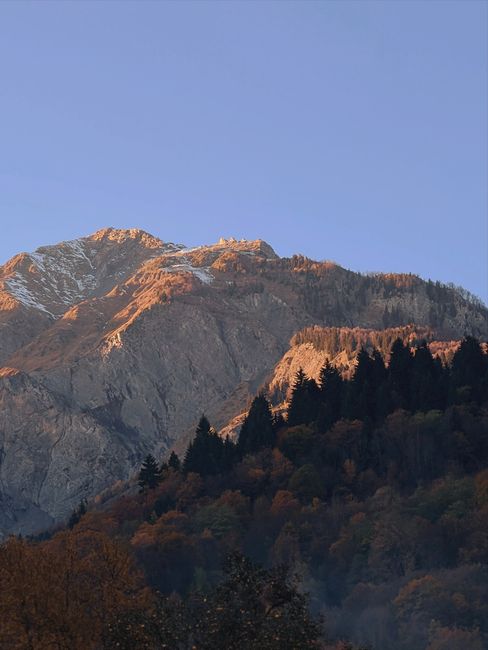 Capture the serene beauty of a mountain range bathed in the warm glow of sunrise.