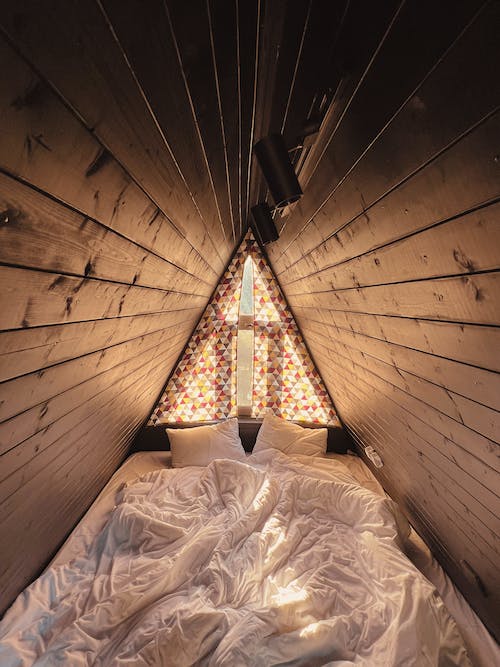 Free Bed with Two Pillows in a Wooden Shed  Stock Photo