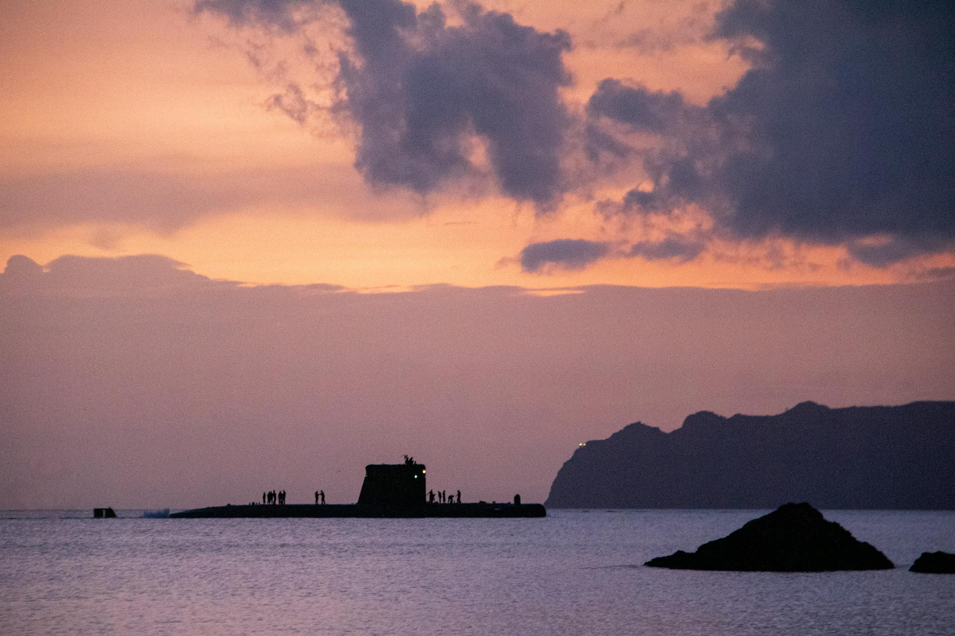 A submarine silhouetted against a stunning sunset sky over the sea near Cartagena, Spain.