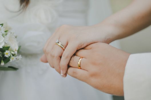 Beautiful close-up of a newlywed couple's hands with wedding rings, symbolizing love and unity.