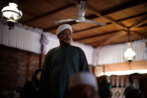 Free Man wearing traditional turban in a warmly lit indoor setting, reflecting cultural richness. Stock Photo